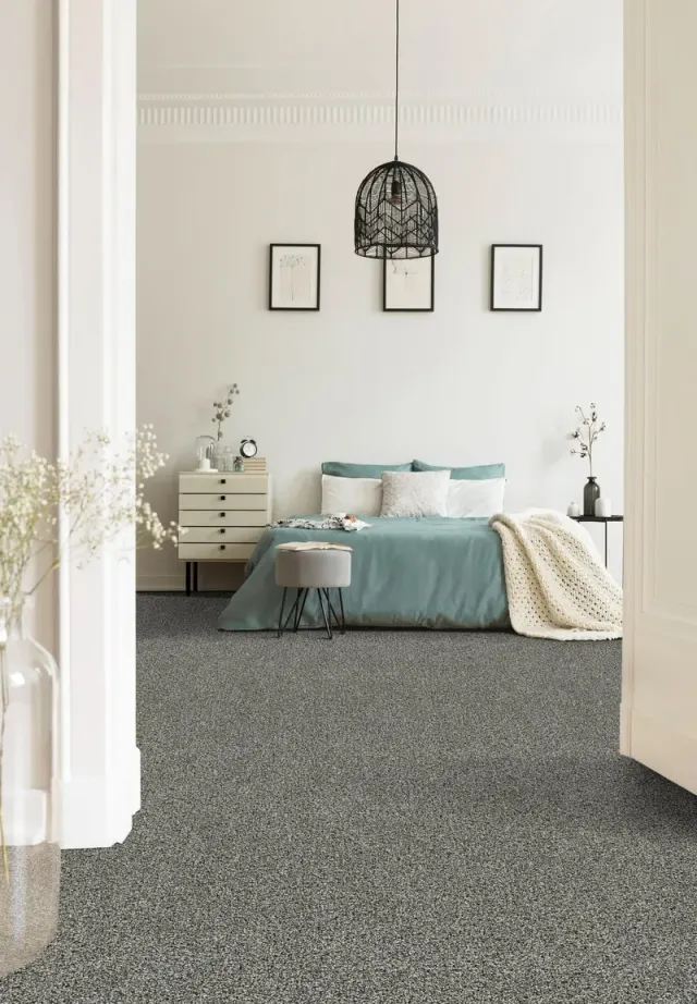 Teal boho bedroom with a pendant light and soft carpet.