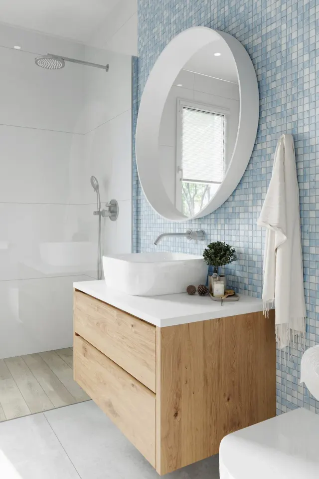 Bathroom with blue mosaic tile flooring and a freestanding tub.
