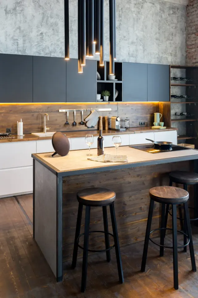Industrial-style kitchen island with warm wood plank flooring.